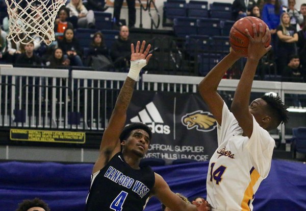 Lemoore's Jaden Jones drives past Hanford West's Jayron Jenkins in the Tigers' overtime win over the Huskies Friday night in the West Hills College Golden Eagle Arena.